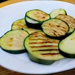 a serving plate with semi-grilled zucchini on it.