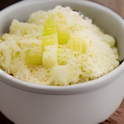 a bowl of creamy cheese with leeks and black pepper.