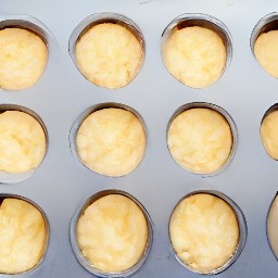 the paper baking cups should be placed in a muffin pan, with the vanilla wafers inside. the cream cheese mixture should then be added to the muffin pan, filling it 2/3 of the way.