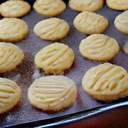 there 8 all-butter shortbreads on the baking sheet, each with a marshmallow on top.