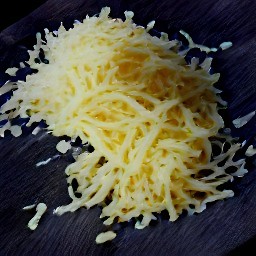 the grater will produce small pieces of gruyère cheese.