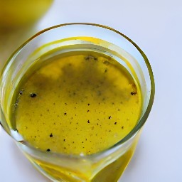 a bowl of olive oil and lemon juice with garlic, oregano, sugar, salt, and black pepper mixed in.