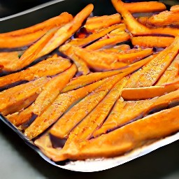 a baking sheet with sweet potato strips, olive oil, cajun seasoning, 1 tsp salt, and 1 tsp black pepper.