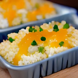 a dish of white rice with sour cream mixture, shredded parmesan cheese and monterey jack cheese.