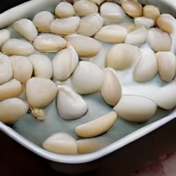 12 garlic cloves in a baking dish with 1 tbsp of olive oil.