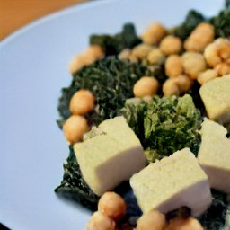 the fried tofu with chickpeas and kale is transferred to a plate.
