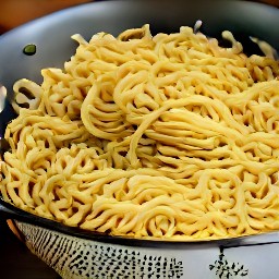 the egg noodles are drained of water in a colander.