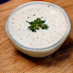 a bowl of lemon soymilk mixed with mayonnaise, dried chives, dried parsley, dried dill, garlic powder, onion powder, salt and black pepper.