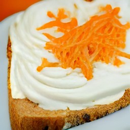 spreading the carrot cream mixture onto cinnamon raisin bread slices.