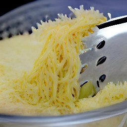 the parmesan cheese is shredded using a grater.