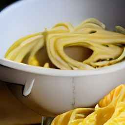 the pasta is transferred to a bowl and drizzled with olive oil.