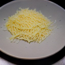 the grated mozzarella cheese is transferred to a plate.
