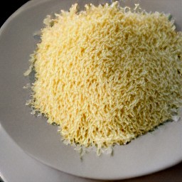 the grated parmesan cheese is transferred to a plate.