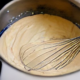 a bowl of batter containing applesauce, vanilla extract, soy milk, mashed bananas and flour.