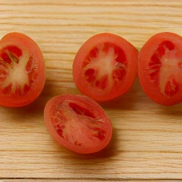 the cherry tomatoes are cut in half.