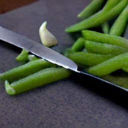 garlic that is peeled and chopped, and green beans that are cut into 2-inch pieces.
