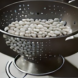 the navy beans are drained in a colander.