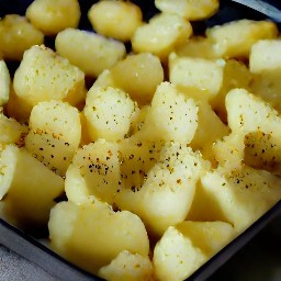a tray of potatoes that have been marinated with cumin, kosher salt, black pepper, and olive oil.