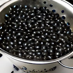 the canned black beans are drained in a colander.