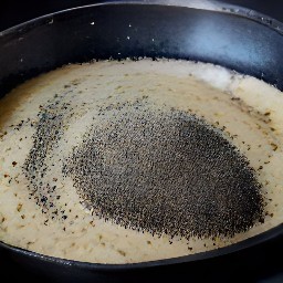 the batter is poured into a pan and poppy seeds are sprinkled over it.