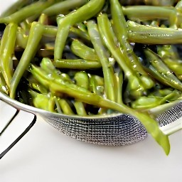 the green beans are drained of water in a sieve.