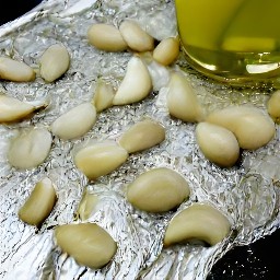 a sheet of aluminum foil with garlic cloves and olive oil on it.