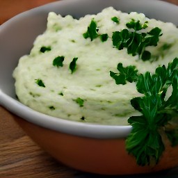a smooth garlic spread that is garnished with chopped parsley.