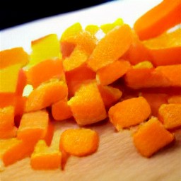 a peeled onion and carrots that are chopped.