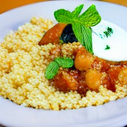 a plate of couscous topped with eggplant tagine and the yogurt mixture.