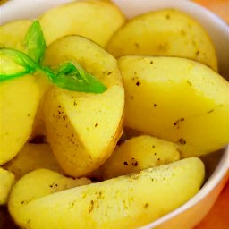 the potato halves are placed in a second bowl, drizzled with dressing, and sprinkled with remaining salt and chopped basil.