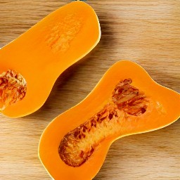 the peeled butternut squash is cut in half.