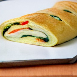 a cookie sheet that has been sprayed with cooking spray and has the folded dough on it. the towel is set aside for 30 minutes, then removed.