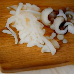 a bowl of chopped onions and sliced shiitake mushrooms.