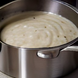 a saucepan containing skimmed milk, cornstarch, cayenne pepper, and black pepper. the saucepan also contains chopped onions.