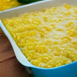 a baking dish containing creamed corn, half of the shredded cheddar cheese, drained whole kernel corn, spaghetti pieces, and whole milk that has been mixed well with a wooden spoon.