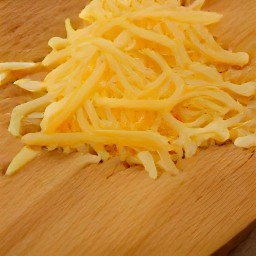 the cheddar cheese is shredded into small pieces.