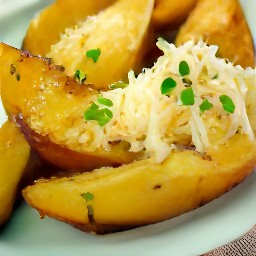 a serving dish of potato wedges with parmesan cheese.