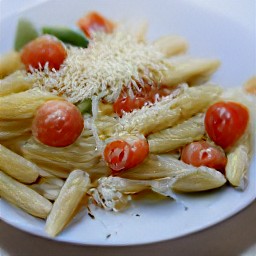 the pasta is transferred to a serving plate and sprinkled with grated parmesan cheese on top.