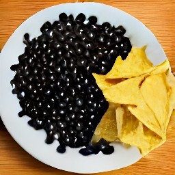 a serving plate with spicy black beans and crushed tortilla chips.