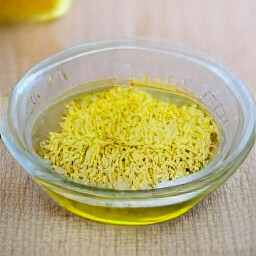 there a bowl containing 0.15 cups of olive oil and a mixture of garlic and lemon zest.