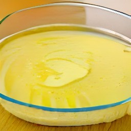 a baking dish filled with butter and sprinkled with garlic powder.