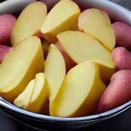 a bowl of dried red potato halves, olive oil, salt, and black pepper that are coated evenly.