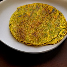a masala spiced omelet on a serving plate.