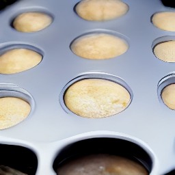 a muffin tin that is sprayed with cooking spray and has batter poured into it 2/3 full.