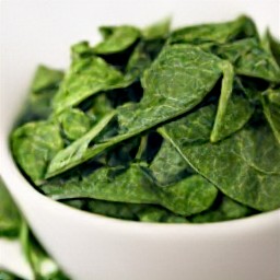 a large bowl of chopped spinach leaves.