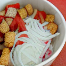 there are onions, bell peppers, and bread cubes in the bowl.