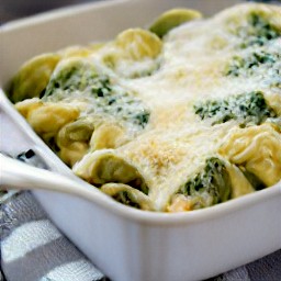 a dish of pasta with mozzarella cheese, parmesan cheese, and pine nuts.