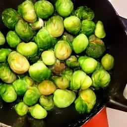 a dish of brussels sprouts with salt, black pepper, butter, brown sugar, maple syrup, walnuts, cider vinegar and walnut oil.