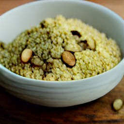 a platter of couscous topped with a mixed nuts mixture.