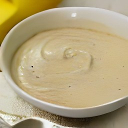 a muffin mixture with mashed bananas, egg whites, whole milk, and sunflower oil mixed in, and raisins added.